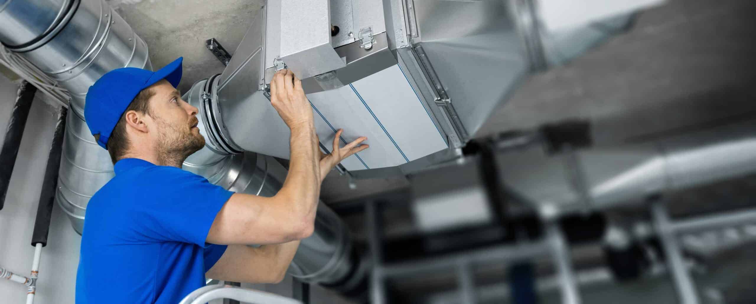 technician checking ductwork inside a home