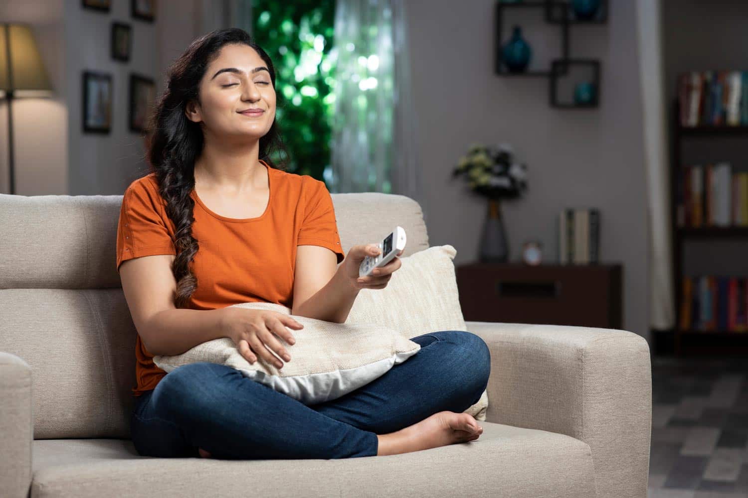 woman using remote for HVAC system